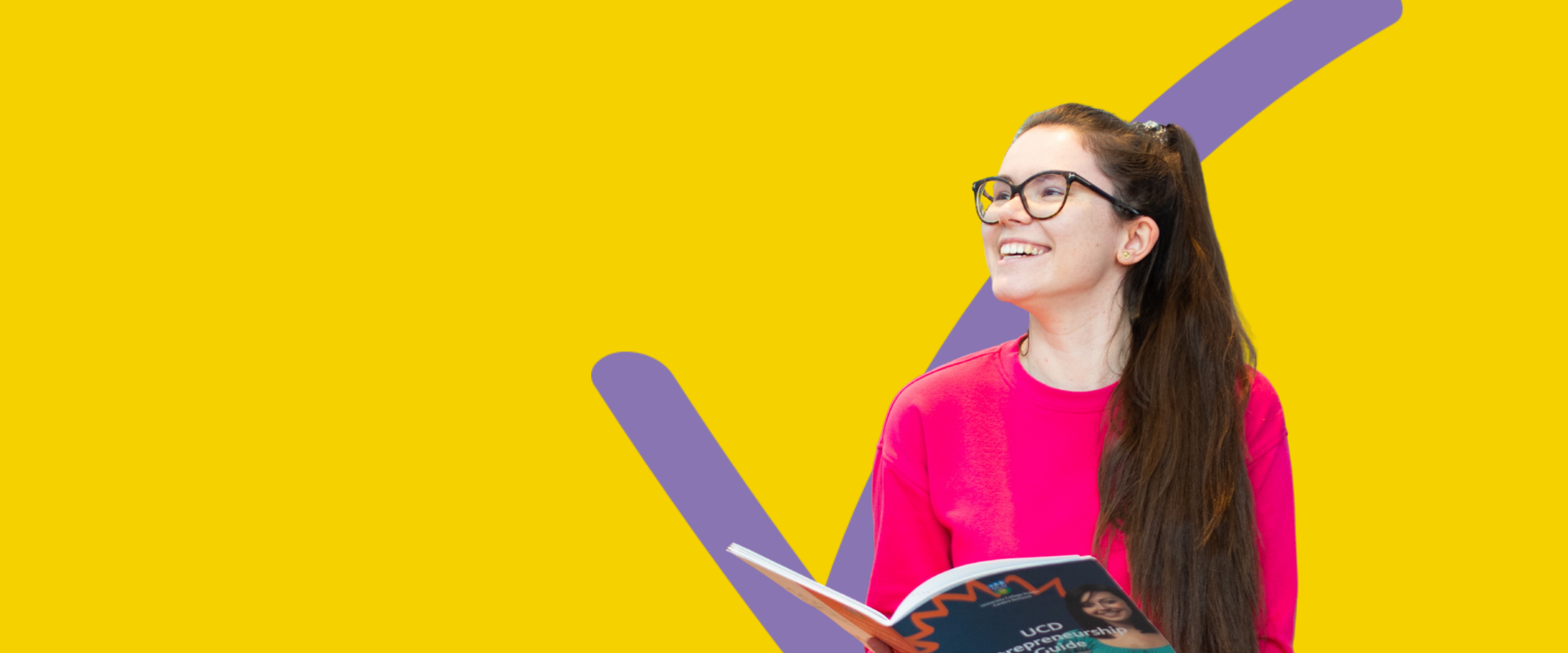 A student smiling against a yellow background